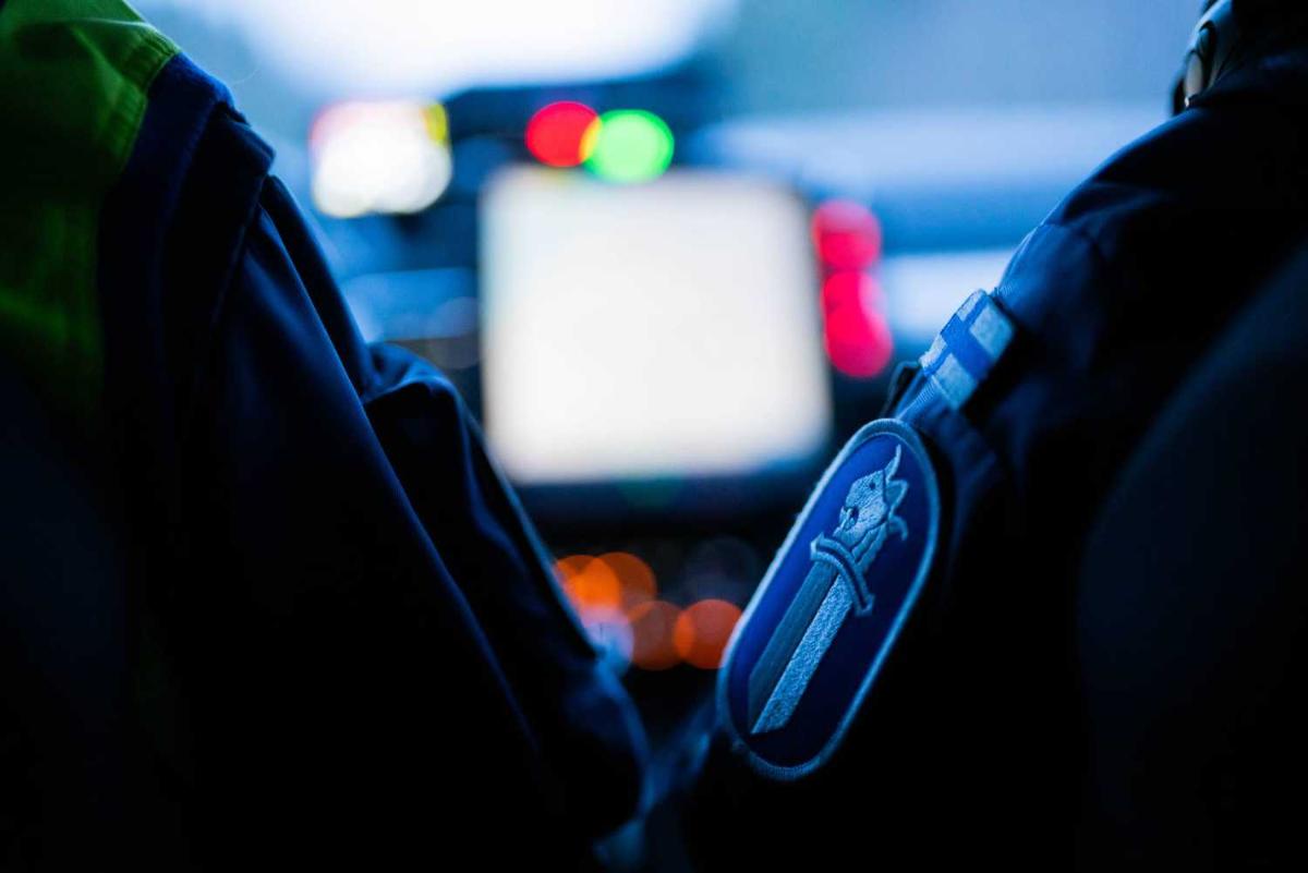 Sisäkuva poliisiauton ohjaamosta. Kaksi poliisia istuu etupenkeissä.