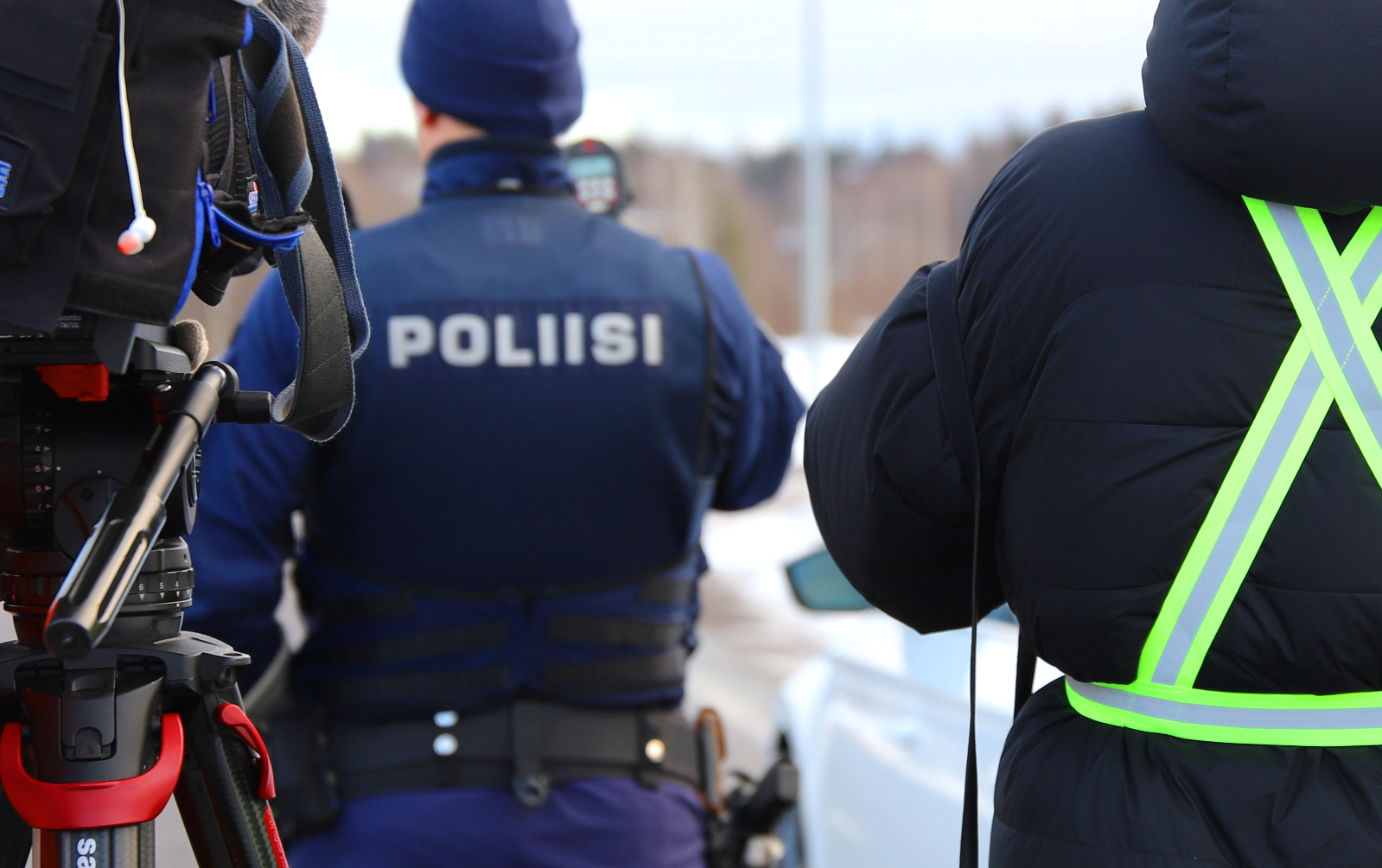 Toimittajat kuvaavat poliisia tiellä.